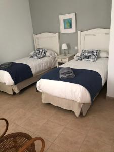 1 Schlafzimmer mit 2 Betten, einem Tisch und Stühlen in der Unterkunft Apartamentos Burgao in Caleta de Sebo