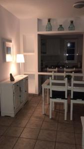 a living room with a table and chairs and a kitchen at Apartamentos Burgao in Caleta de Sebo
