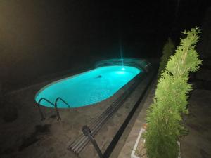 una piscina blu di notte con apertura di Villa Unique a Eşelniţa