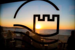 un restaurante con vistas a la puesta de sol en Hotel El Castillo de Los Locos en Suances