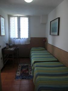 a small bedroom with a bed and a window at App To Golfo Stella - Trilocale in Capoliveri