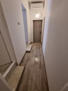 an empty hallway with a door and wooden floors at U kalici in Mali Lošinj
