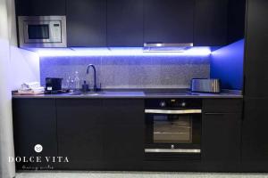 a black kitchen with a sink and a stove at Apartamento Napoli living suites en Vila real in Villareal