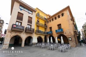 a group of tables and chairs in front of a building at Apartamento Napoli , living suites en Vila real in Villareal