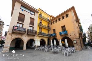 a group of tables and chairs in front of a building at Apartamento Napoli living suites en Vila real in Villareal