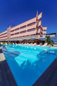 un hotel con piscina di fronte a un edificio di Onda Hotel a Silvi Marina