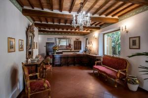 sala de estar con mesa, sillas y lámpara de araña en Hotel Vecchia Oliviera en Montalcino