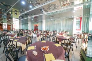 a banquet hall with tables and chairs with a plate of food at Hotel Orizzonte in Silvi Marina