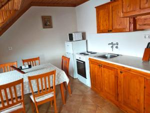 a kitchen with a table and a white stove top oven at Hangulat Vendégház / Apartman in Harkány