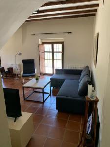 sala de estar con sofá azul y mesa en Castillo con piscina en plena Sierra Calderona, en Segorbe