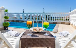 a table with two glasses of wine next to a pool at Villa San Rocco Bed & Breakfast in Medulin