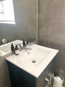 a bathroom with a white sink and a bath tub at Impa-Lala Country Estate in Bloemfontein