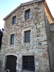 um antigo edifício de pedra com janelas e uma porta em La Masia de Rendé Masdéu em Espluga de Francolí