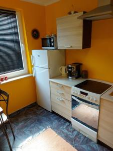 a kitchen with a white refrigerator and a stove at Apartament Retro Promenada in Ełk +12 photos