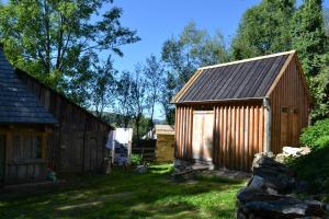 a small wooden shed in a yard with trees at Casa Carolina in Roşia Montană