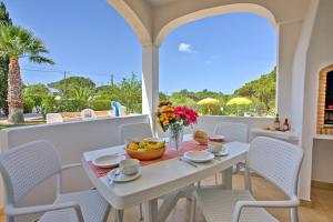 a white table and chairs on a balcony at Villa Candida by Villa Plus in Vale do Lobo