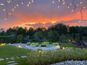 a garden with a fire pit at sunset at Alpina Luxury Chalets in Banya