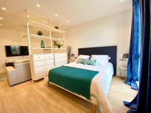 a bedroom with a large bed and a white dresser at Magnifique Studio à deux pas du port de Saint-Tropez in Saint-Tropez