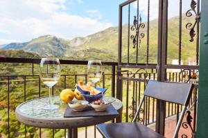 a table with two glasses of wine and fruit on a balcony at il Magàn - Cinque Terre in Corniglia