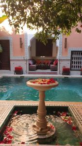 un plato de comida en una mesa frente a una piscina en Riad Barroko, en Marrakech