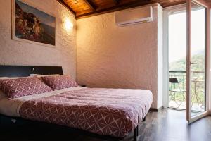 a bedroom with a bed and a large window at il Magàn - Cinque Terre in Corniglia