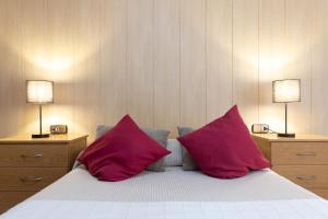 a bedroom with two red pillows on a bed at RNET - Madrid 33 - Roses Costa Brava in Roses