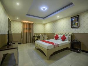 a bedroom with a bed and a television in it at OYO 700 Pj Inn Hotel in Pampang