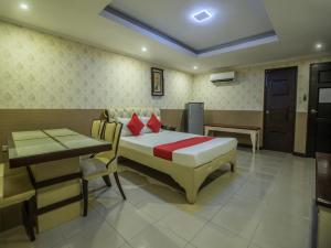 a bedroom with a bed and a table and a desk at OYO 700 Pj Inn Hotel in Pampang