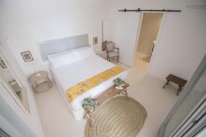 a small bedroom with a bed and a chair at Villa Dora (Only adults) in Jávea