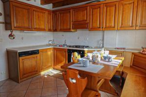 a kitchen with wooden cabinets and a wooden table at Casa Francesca - Relax nel cuore delle Dolomiti in Pieve di Cadore