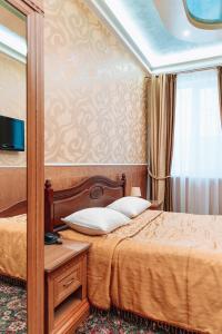 Schlafzimmer mit einem Bett und einem Spiegel in der Unterkunft Viktoriya Family Hotel Restaurant complex in Kiew