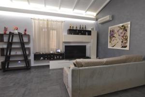 een woonkamer met een bank en een televisie bij Holiday Home Solarino - ISI02101h-F in Solarino