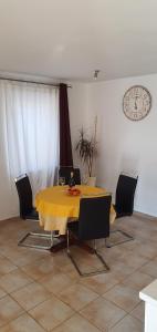 a dining room table with a yellow table cloth on it at Nevija in Peroj