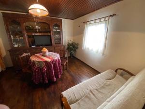 a living room with a table and a couch at Alojamento da Ribeirinha in Cárquere +62 photos