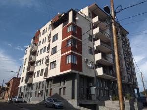 um edifício alto numa rua com um carro estacionado na frente em Avlabari Old Town Residence em Tbilisi