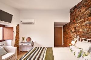 a bedroom with a stone wall and a bed and a couch at Casa da Eira in Janeiro de Cima +32 photos