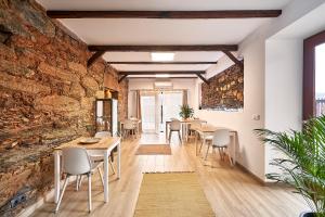 a dining room with a stone wall and tables and chairs at Casa da Eira in Janeiro de Cima