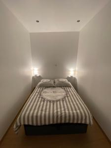 a small bedroom with a bed with two lights on it at Appartement cosy au cœur des Vosges in Épinal