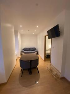 a room with two beds and a flat screen tv at Appartement cosy au cœur des Vosges in Épinal