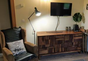 a living room with a chair and a flat screen tv at SOLDEU cosy home in Soldeu