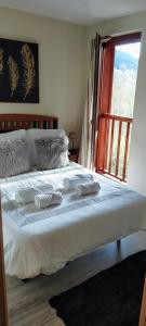 a bedroom with a large white bed with a window at SOLDEU cosy home in Soldeu