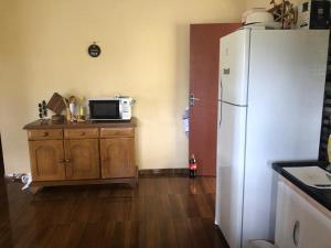 eine Küche mit einem weißen Kühlschrank und einer Mikrowelle in der Unterkunft Chácara Cantinho do Ipê in Marechal Floriano + 38 Fotos