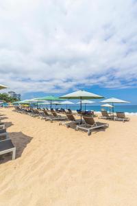 a row of chairs and umbrellas on a beach at Suites at Sapphire Ocean Club in Puerto Vallarta
