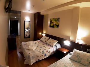 una camera d'albergo con due letti e uno specchio di Hostal Nirvana a Ponferrada