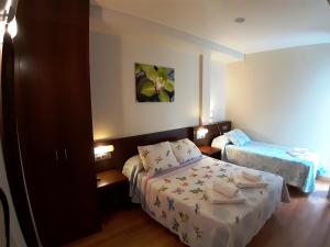 a bedroom with a bed and a dresser at Hostal Nirvana in Ponferrada