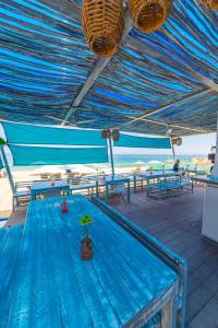 a deck with blue tables and benches and the ocean at Suites at Sapphire Ocean Club in Puerto Vallarta