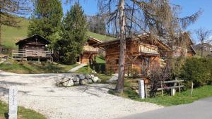 une cabane en rondins avec une route devant elle dans l'établissement BARMADZA Mazots de Charme, à Demi-Quartier