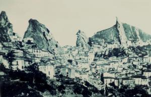 a black and white photo of a city with a mountain at ACQUARIO in Pietrapertosa