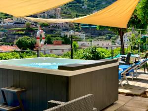 a hot tub on a patio with a view at Eden Holiday in Minori