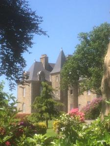 an old castle with flowers in front of it at Château de Montbrault in Fleurigné +11 photos